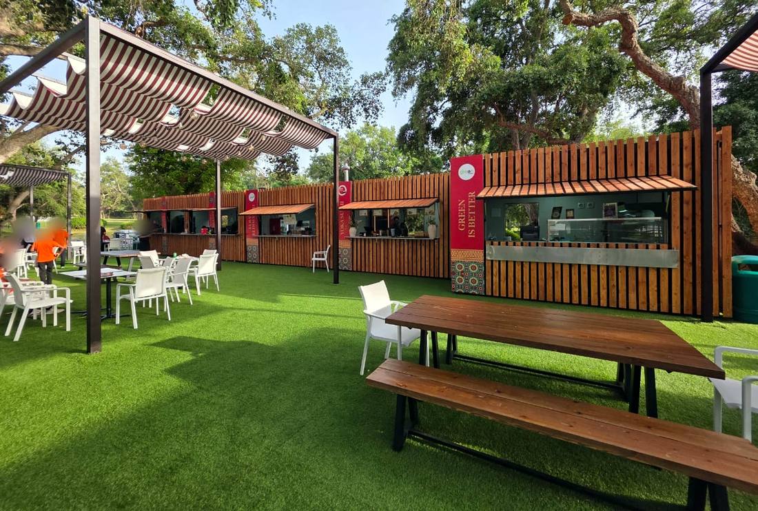 Village de kiosques MZL en bois sous pergolas à toile rayée